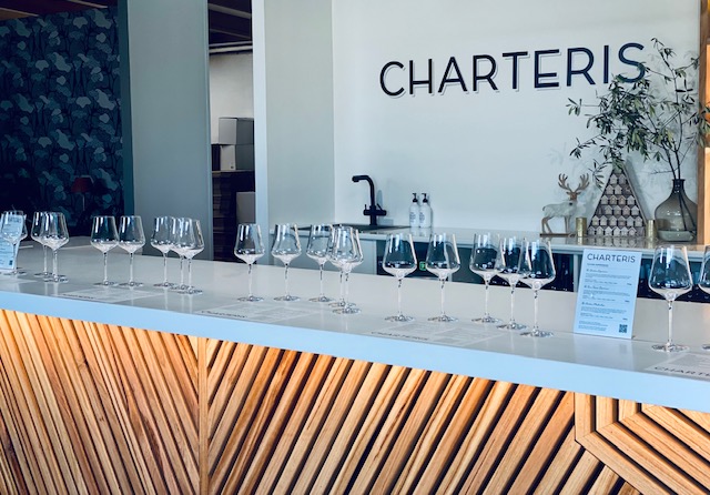 Wine glasses lined up on top of bar 